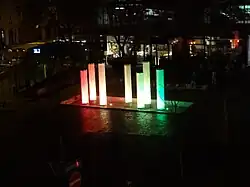 Brunnen mit Glasröhren, die von innen farbig beleuchtet werden