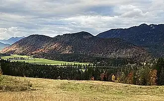 Bergrücken des Brunnenbergs und Hochenkopfs von Südosten, oberhalb des Jachentals mit dem Ortsteil Höfen der Gemeinde Jachenau; am linken Bildrand der Herzogstand, am rechten der Latschenkopf (Jachenau)