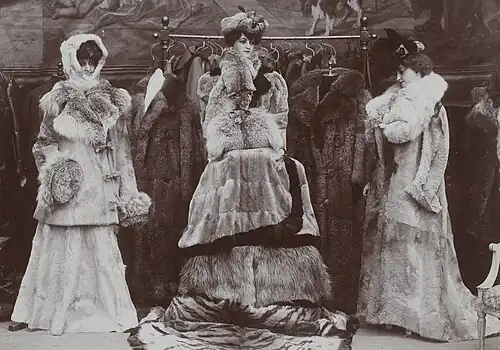 Links: Rock und Jacke Fohlenfell, Verbrämung aus Luchsfell, Kapuze Hermelinfell Mitte: Pelzdecken, Pelzjacke, Pelzkopfbedeckung, Luchskollier, Luchsmuff Rechts: Fohlenmantel mit Luchskragen Im Hintergrund: Australisch Opossummäntel