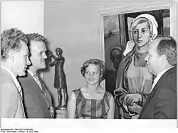 Womacka (rechts) und seine Frau Hanni mit Ausstellungsbesuchern vor seinem Bild Junge Genossenschaftsbäuerin (1960)