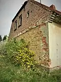 Südansicht, hinter den luftgetrocketen Ziegeln der ehem. Pferdestall