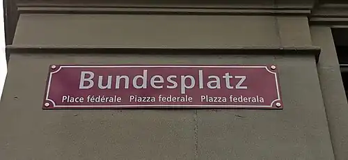 Bundesplatz: rotes Schild, viersprachig seit 2020[8]