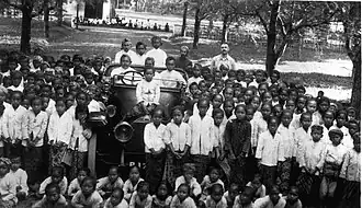Schulkinder gruppiert um das erste Auto am Ort