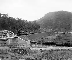 Zug der Padangbahn im Sawahlunto-Tal, im Hintergrund Berg mit Kohle-Lagerstätte