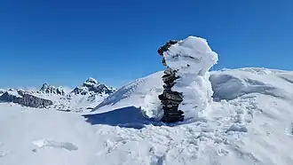 Steinmännchen auf dem Gipfel, im Hintergrund der Piz Platta