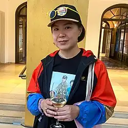 Cao Fei mit Käppi und Glas Weißwein während ihrer Vernissage im Lenbachhaus