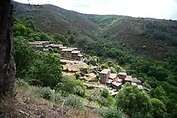 Cerdeira (Lousã) - Schieferdorf in der Serra da Lousã, Portugal, das sich in das Tal schmiegt, aus mit Steinen gedeckten Häusern mit flach geneigten Dächern, welche durch Braun-, Rot- und Grautöne der Steine recht bunt wirken.