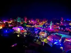 Aufnahme des CCCamps bei Nacht, hell erleuchtet von vielen LED Installationen