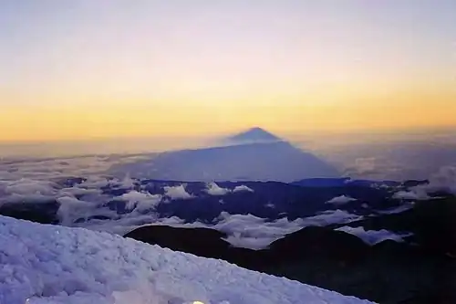 Sonnenaufgang auf dem Gipfel des Chimborazo, Blick nach Westen auf den geworfenen Schatten.