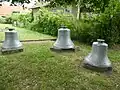 Drei Stahlglocken auf dem ehemaligen Kirchhof südlich vor der Kirche (2025)