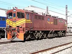 E7058 in Golfrot und mit gelben „Schnurrhaaren“ im Depot Swartkops bei Port Elizabeth am 22. April 2013