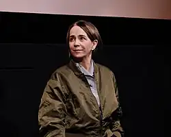Constanze Ruhm in grüner Bomberjacke vor Kinoleinwand