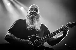 Der Stoner-Musiker Brant Bjork (links), hier in der Kantine in Augsburg, mit langen krausen Haar und Stirnband ist ebenso wie der positiv gestimmte Kirk Windstein (rechts), hier mit Crowbar beim Roadburn Festival, mit seinem rasierten Kopf und langen Bart, populäre Musiker wie Stereotype der Doom-Metal-Szene.