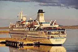 Kreuzfahrtschiff Berlin im Licht der Mitternachtssonnen an einer Pier im Hafen von Honningsvåg