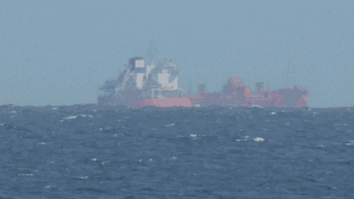 Serie von Teleobjektivaufnahmen: Ein Frachtschiff scheint mit zunehmender Entfernung nicht nur kleiner zu werden, sondern auch zu „sinken“