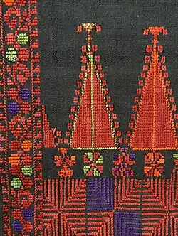 Die palästinensische Stickerei zeigt Jaffa-Zypressen und Mondmuster im unteren Bildbereich