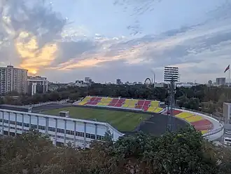 Das Dölön-Ömürsakow-Stadion von Hotel Plaza aus fotografiert. Im Hintergrund Riesenrad von Bishkek (Juli 2025).