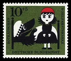 Rotkäppchen am Bett der Großmutter, in dem der verkleidete Wolf liegt.