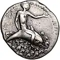 Didrachme. (ca. 450-440 v. Chr.), 25 mm. Delfinreiter nach r. Der l. Arm ist nach vorn ausgestreckt. Mit der r. Hand stützt er sich hinten auf den Delphin. Um den Fisch herum Wellen. (Avers).[70]