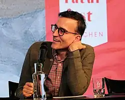 Daniel Schreiber während einer Lesung, zuhörend