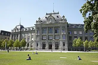 Das Hauptgebäude der Universität Bern im Sommer mit Parkterrasse im Vordergrund.