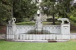 Die Brunnenanlage im Davoser Kurgarten wurde ursprünglich von Wilhelm Schwerzmann (1877–1966) zusammen mit den Granitwerken Andeer für die Landesausstellung 1914 in Bern geschaffen. Der ursprünglich ohne Schmuck gestaltete Brunnen erhielt 1940–41 die drei Figuren (Bär, Steinbock, Wolf), welche auch von Wilhelm Schwerzmann hergestellt wurden.