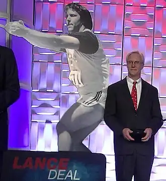 Lance Deal 2014 vor einem Foto aus seiner aktiven Zeit