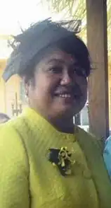 Debbie Remengesau. Pazifische Frau im gelben Kostüm mit einem interessanten, strauchartigen „Faszinator“. 2017