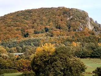 Blick von Südwesten zum herbstlichen Hirzstein mit Brücke der A 44 über die Verbindungsstraße Elgershausen–Firnsbachtal