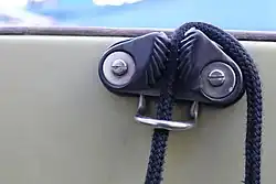 Schwarze Leine, die zwischen zwei geriffelten Blöcken eingeklemmt ist