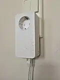 dLAN650, älterer PowerLAN-Adapter von Devolo mit Steckdosendurchschleifung sowie angeschlossenem LAN-Kabel[12]