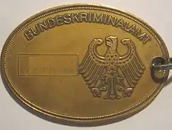 Kriminaldienstmarke des deutschen Bundeskriminalamtes (Rückseite) – Nummer mit Bildbearbeitung entfernt