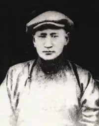 Dogsomyn Bodo. Schwarzweißfotografie eines Mannes in traditioneller mongolischer Kleidung mit flachem Filzhut.