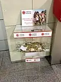 Spendenbox der Caritas Kosovo im Flughafen Pristina.