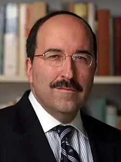 Dore Gold. Portrait eines Mannes mit hoher Stirn, randloser Brille und Schnurrbart.