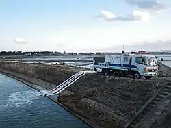 Drainagepumpe im Einsatz zur Entwässerung der überfluteten Felder in Watari mit einem Fahrzeug des MLIT