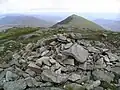 Der Gipfelcairn des Druim Shionnach, im Hintergrund der östlich liegende Creag a’ Mhaim