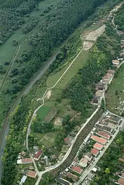 Kastell Lussonium: das Kastellareal auf dem Lößhügel von Norden. Dort, wo heute ein Kanal verläuft, floss bis in das 19.&nbsp;Jahrhundert die Donau. Anstelle des heutigen Dorfes Dunakömlőd am Westrand des Lößhanges befand sich auch das römische Lagerdorf.