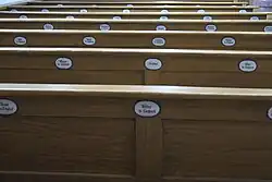 Kirchenbänke mit Namensschildern