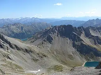 Napfspitze (etwas rechts der Bildmitte) von Nordwesten, vom Östlichen Hochwart. Links der Neves-Stausee, rechts der Eisbruggsee.