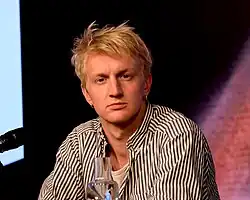 Elias Krischke schaut während einer Lesung direkt in die Kamera