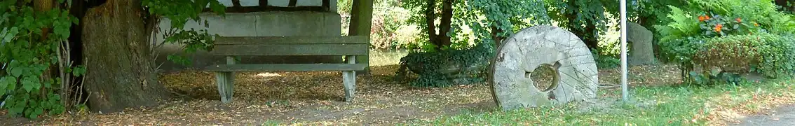 Historischer Mühlstein am Eingang.