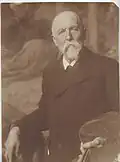 Der 80-jährige Hildebrand im Atelier vor seinem letzten großen Gemälde Die Kreuzigung Christi (1913)