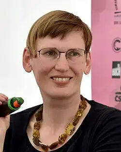 Porträtfoto von Eva von Redecker, eine Frau mit einer dunklen Kurzhaarfrisur und Brille, sie schaut von links nach rechts