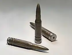 Exerzier­patrone der Bundeswehr für das HK G3 (7,62 × 51 mm NATO). Deut­lich sichtbar sind die Ein­ker­bungen, um Verwechslung mit scharfer Munition zu vermeiden, und die Aus­sparung im Boden, um den Schlag­bolzen beim Ab­schlagen aufzunehmen.