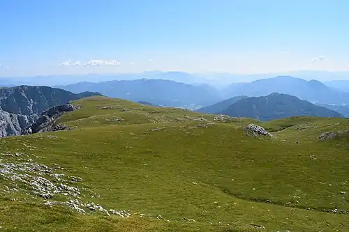 …und ist vom höheren Fölzkogel aus doch nur eine sanfte Wiesenfläche (Gipfelkreuz links hinten).