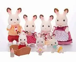 Auf dem Foto sind sieben Spielfiguren zu sehen, die eine Hasenfamilie darstellen. Die Eltern sind mehrere Zentimeter groß, die beiden Kinder etwas kleiner. Die Hasen haben ein weißes Fell, pinke Nasen, schwarze Knopfaugen und rosa Innenohren mit einer weiß-braunen Umrandung. Sie tragen von links nach rechts: Ein orange-weiß kariertes Hemd mit zwei roten Knöpfen sowie rote Shorts. Ein rotes Kleid mit weißen Punkten und einen orange-blumenförmigen Anstecker unterm Kragen. Ein weiß-rot kariert-gestreiftes Hemd mit zwei roten Knöpfen und beige Shorts. Ein lila Kleid mit einer dunkelroten Schleife unterm Kragen sowie eine weiße Schürze mit roten Punkten. Vor der Familie sind drei deutlich kleinere Baby-Hasen platziert. Sie tragen von links nach rechts ein rotes Kleid, einen rosa Strampler sowie eine orange Hose mit weißen Blumen am oberen Rand. Das erste Baby steht in einer Wiege, daneben befindet sich eine Babyflasche mit rosa Deckel. Das zweite Baby hat eine Flasche mit gelbem Deckel, das dritte einen hellblauen Schnuller im Mund.