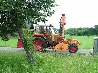 Fendt GT mit aufgebautem Mulchausleger und oranger Kommunallackierung – Ein Geräteträger