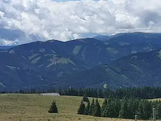 Blick vom Wetterkogel nach Südwesten. In der Bildmitte die Fensteralm, links der Pöllakogel. Am rechten Bildrand der Eiblkogel, rechts mittig im Hintergrund der spitze Gipfel des Roßbachkogels.