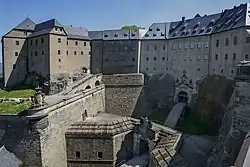 Toranlage aus verschiedenen Bauphasen.Links der Kernbau aus dem Mittelalter (Georgenburg, umgebaut 1605), davor die „Ge­or­genbatterie“ 1669, rechts Er­weite­rungen 1589–1591 (Streich­wehr u. zwei­mal geknicktes Torhaus), vorn Graben;schere aus dem 18.&nbsp;Jh.